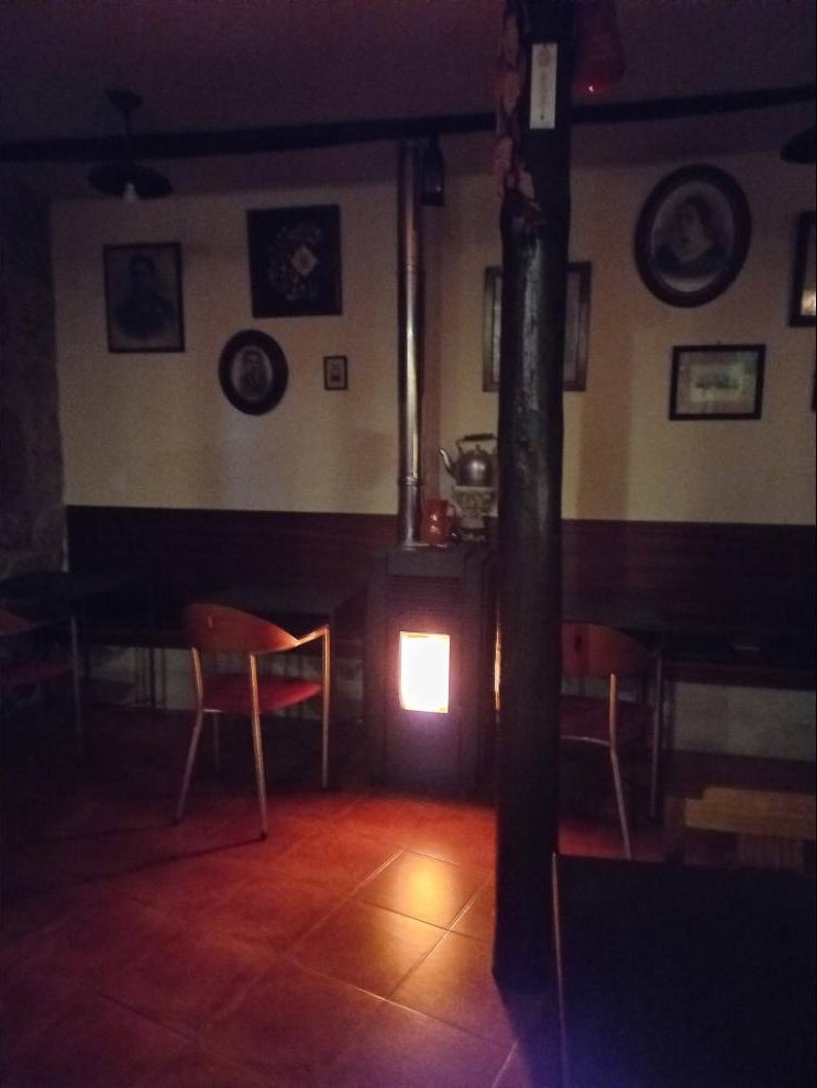 Sala da tasca com salamandra acesa e retratos antigos na parede